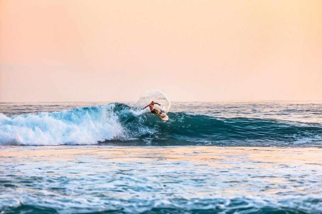 Surfer riding a wave at sunset